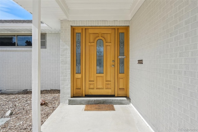 entrance to property featuring brick siding