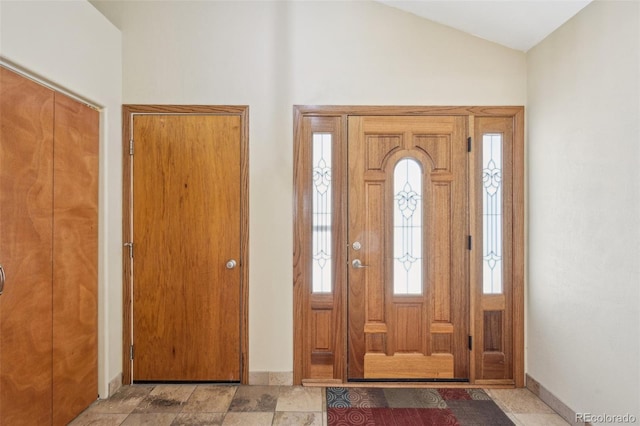 entrance foyer featuring baseboards and vaulted ceiling