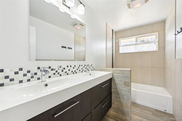 bathroom featuring double vanity, visible vents, tasteful backsplash, and a sink