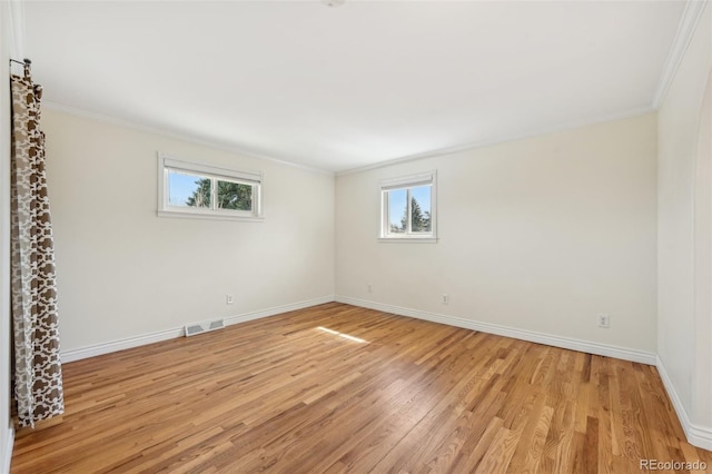 spare room featuring plenty of natural light, crown molding, and visible vents