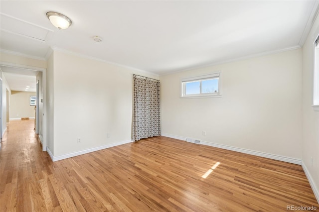 empty room with light wood-style flooring, baseboards, and ornamental molding