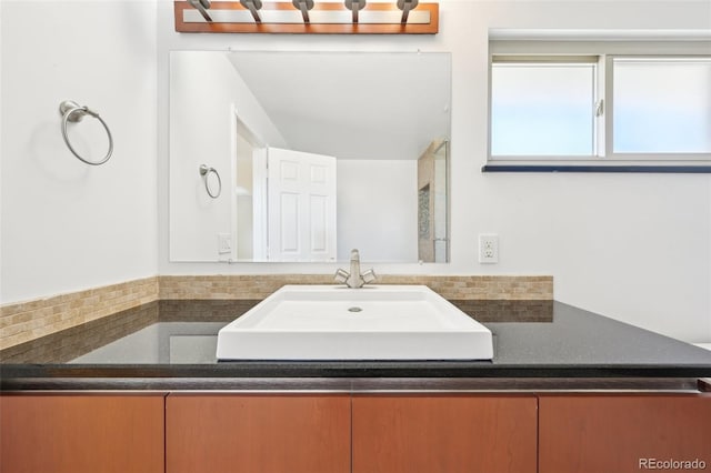 bathroom with tasteful backsplash and vanity