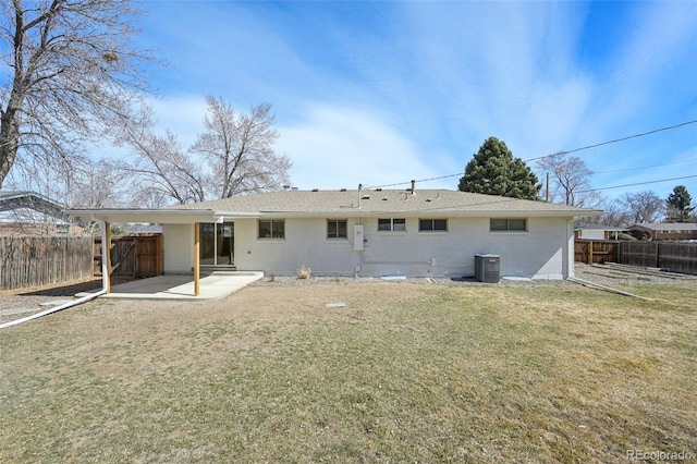 back of house featuring a patio, a yard, a fenced backyard, central AC, and brick siding