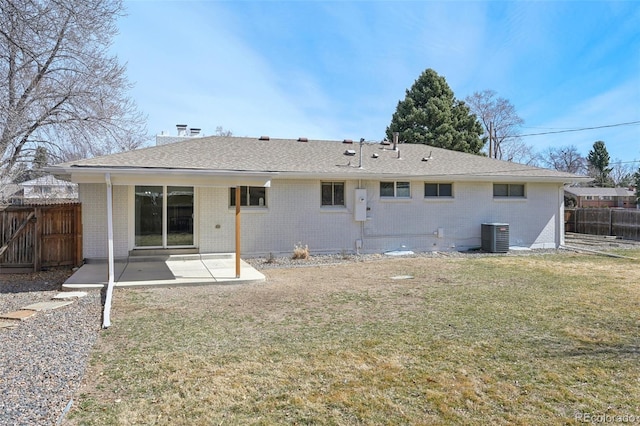 back of property with a patio area, fence, brick siding, and a lawn