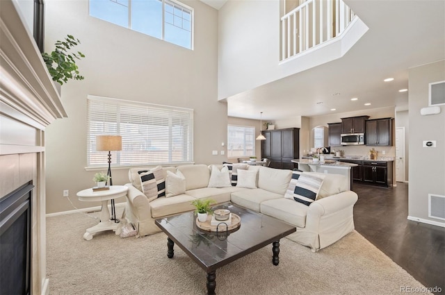 living area with recessed lighting, a healthy amount of sunlight, a tile fireplace, and baseboards