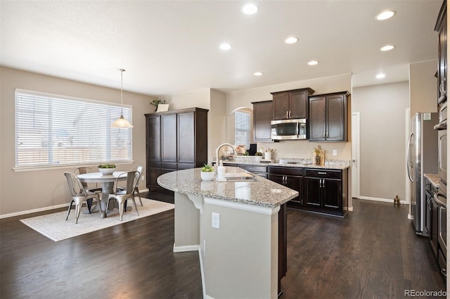 kitchen with a healthy amount of sunlight, dark wood-type flooring, dark brown cabinetry, stainless steel appliances, and a sink