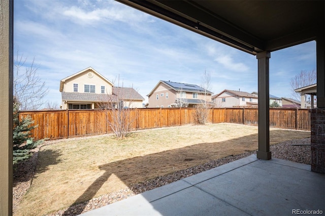 view of yard featuring a residential view, a patio, and a fenced backyard