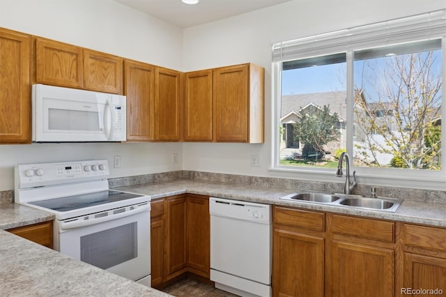 719 Elk Mountain Dr, Severance, CO 80550 - kitchen featuring white appliances, a sink, light countertops, and brown cabinets