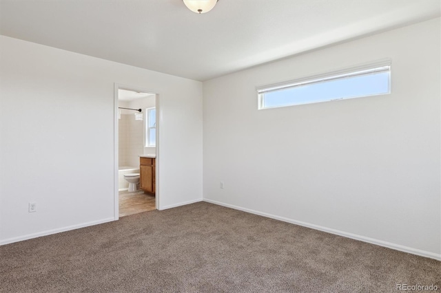 719 Elk Mountain Dr, Severance, CO 80550 - unfurnished bedroom with light colored carpet, baseboards, and ensuite bath