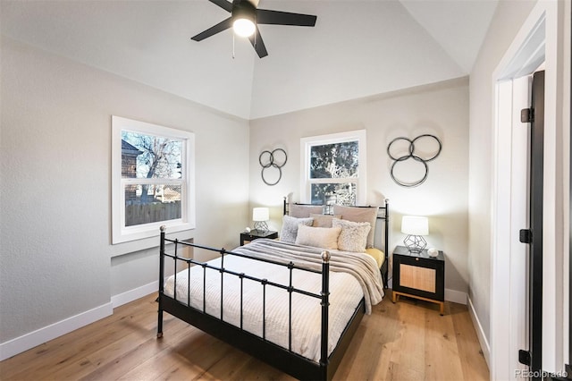 bedroom featuring multiple windows, wood-type flooring, and vaulted ceiling