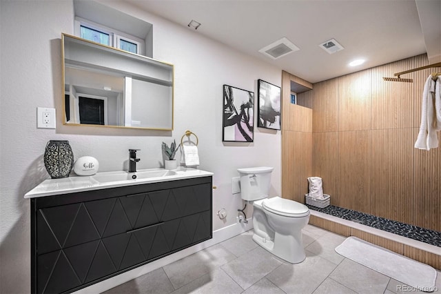 bathroom with tile patterned flooring, vanity, a shower, and toilet