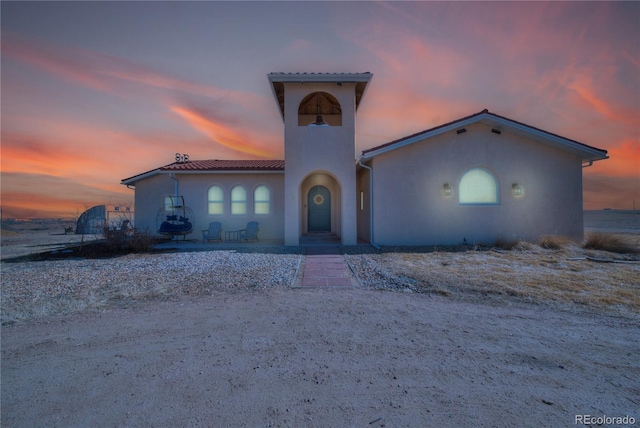 mediterranean / spanish home with a tiled roof and stucco siding