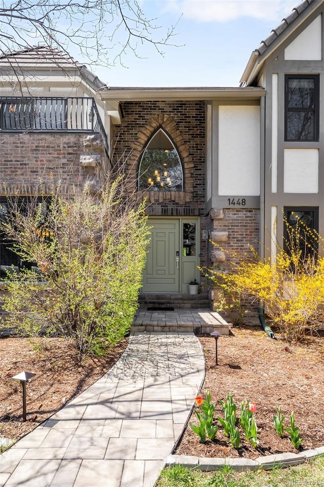 property entrance with stucco siding and brick siding
