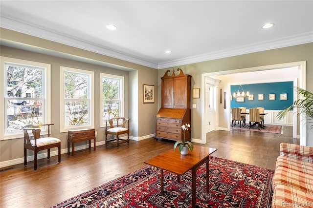 living area with ornamental molding, wood finished floors, and plenty of natural light
