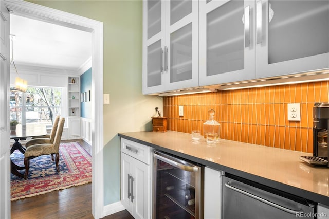 bar with tasteful backsplash, crown molding, a dry bar, dark wood-style flooring, and wine cooler