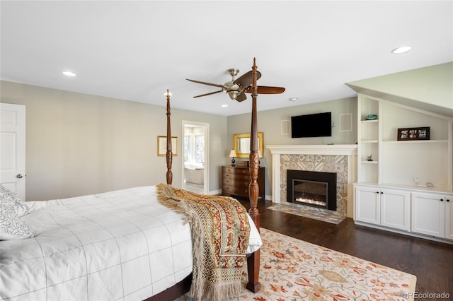 bedroom featuring a fireplace, recessed lighting, and dark wood finished floors