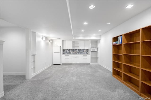unfurnished living room featuring recessed lighting, light carpet, and baseboards