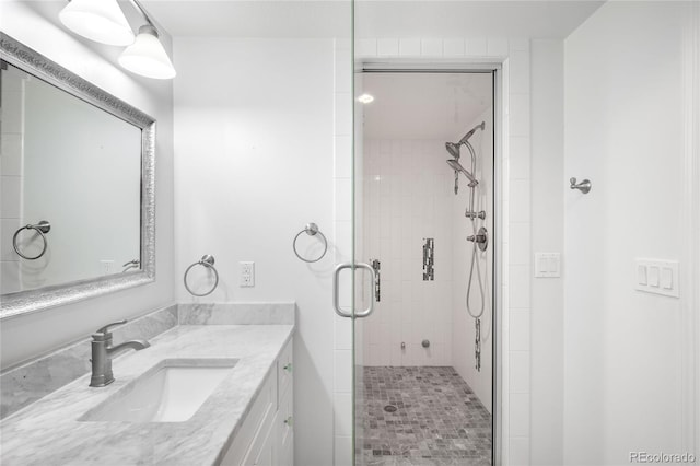 bathroom with a shower stall and vanity