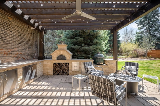 view of patio / terrace with an outdoor kitchen, a pergola, grilling area, ceiling fan, and a fireplace
