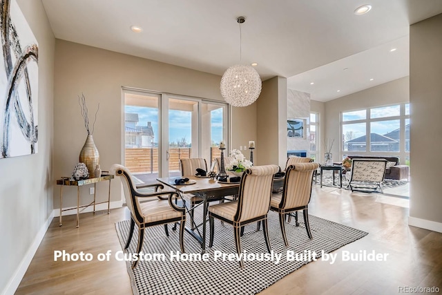 dining room with recessed lighting, a large fireplace, baseboards, and wood finished floors