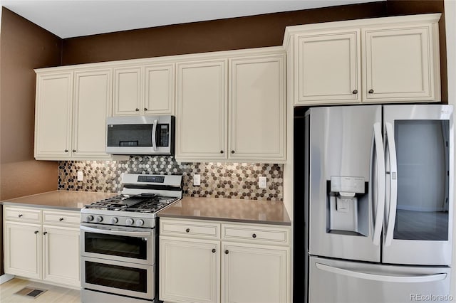 5154 Taft Ct, Wheat Ridge, CO 80033 - kitchen featuring stainless steel appliances, backsplash, light countertops, and white cabinetry