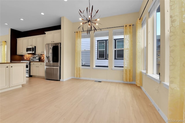 5154 Taft Ct, Wheat Ridge, CO 80033 - kitchen featuring appliances with stainless steel finishes, light wood finished floors, a chandelier, decorative backsplash, and recessed lighting