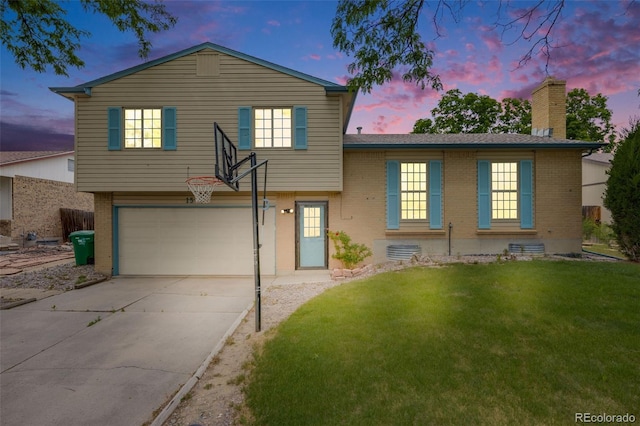 1549 S Evanston St, Aurora, CO 80012 - tri-level home with brick siding, a garage, a chimney, driveway, and a lawn