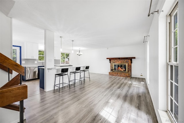 1549 S Evanston St, Aurora, CO 80012 - living area featuring wood finished floors, a fireplace, and a chandelier