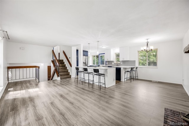 1549 S Evanston St, Aurora, CO 80012 - kitchen featuring a breakfast bar area, stainless steel fridge with ice dispenser, light countertops, light wood finished floors, and white cabinets
