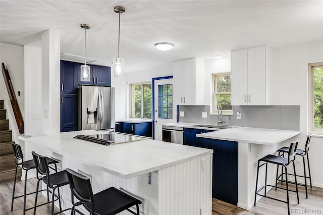 1549 S Evanston St, Aurora, CO 80012 - kitchen with blue cabinetry, stainless steel appliances, a sink, and a peninsula