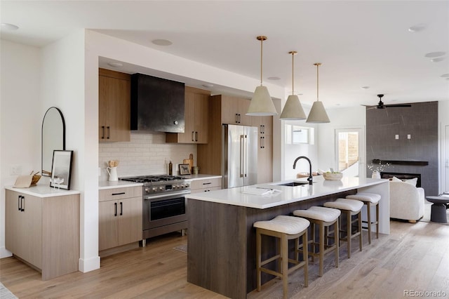 3435 W 17th Ave, Denver, CO 80204 - kitchen featuring high quality appliances, extractor fan, backsplash, a breakfast bar area, and light wood-style floors