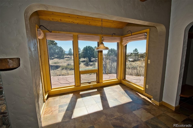 1507 Wagon Wheel Rd, Crestone, CO 81131 - entryway with stone finish floor, a textured wall, arched walkways, and baseboards