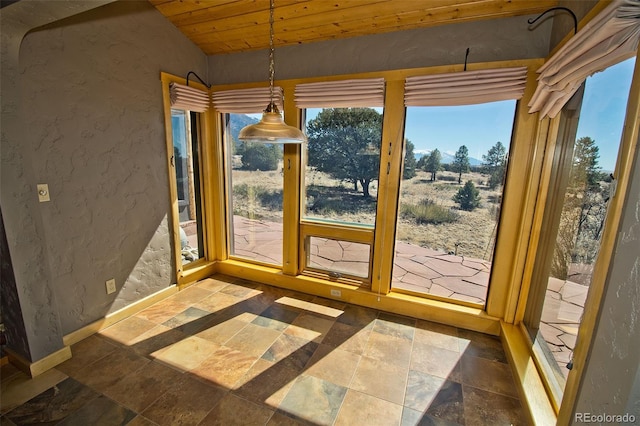 1507 Wagon Wheel Rd, Crestone, CO 81131 - doorway with stone tile floors, baseboards, vaulted ceiling, wooden ceiling, and a textured wall