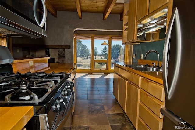 1507 Wagon Wheel Rd, Crestone, CO 81131 - kitchen featuring beamed ceiling, brown cabinets, a sink, appliances with stainless steel finishes, and wood ceiling
