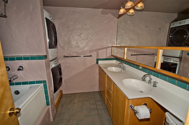 1507 Wagon Wheel Rd, Crestone, CO 81131 - bathroom featuring tile walls, stacked washer and dryer, a bathing tub, and a sink