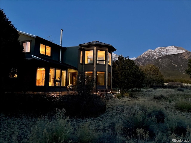 1507 Wagon Wheel Rd, Crestone, CO 81131 - back of house with stucco siding and a mountain view
