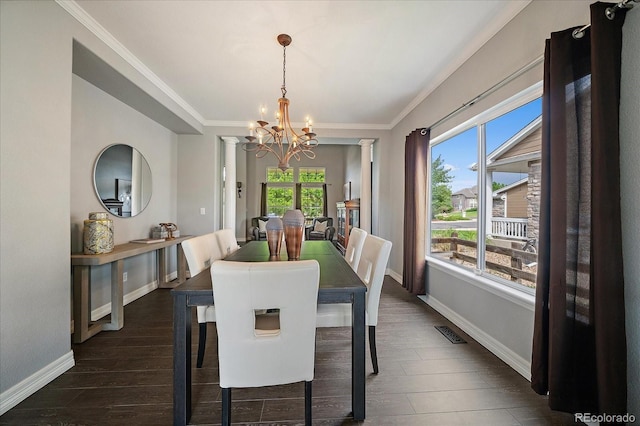 11691 Riverdale Dr, Parker, CO 80138 - dining space with a chandelier, dark wood-type flooring, ornamental molding, and decorative columns