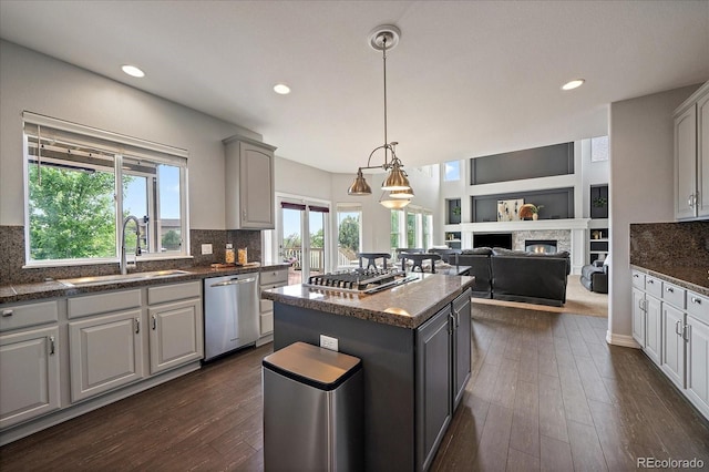 11691 Riverdale Dr, Parker, CO 80138 - kitchen featuring appliances with stainless steel finishes, dark countertops, dark wood-style flooring, a kitchen island, and recessed lighting
