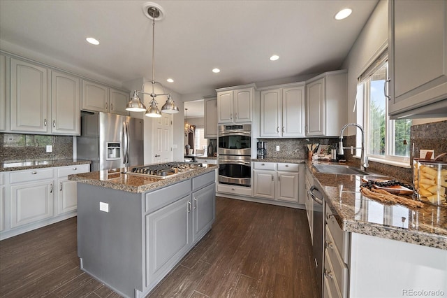 11691 Riverdale Dr, Parker, CO 80138 - kitchen with stainless steel appliances, a center island, tasteful backsplash, recessed lighting, and dark wood finished floors