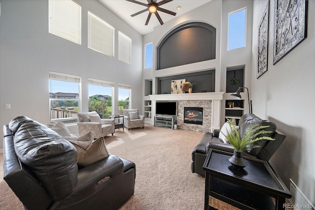 11691 Riverdale Dr, Parker, CO 80138 - carpeted living room featuring a towering ceiling, ceiling fan, a stone fireplace, and built in shelves