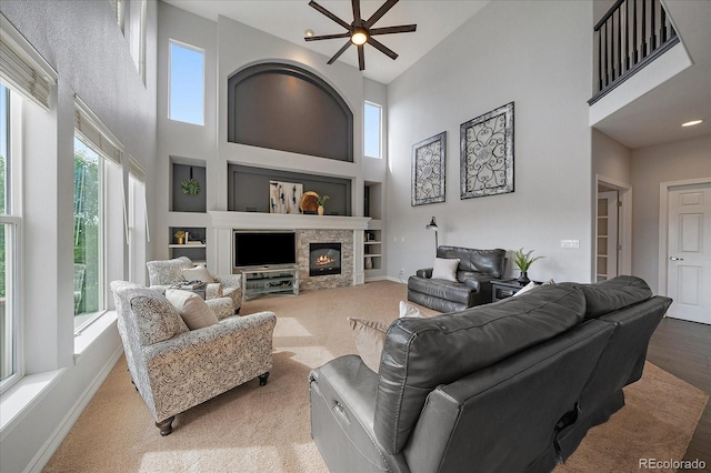 11691 Riverdale Dr, Parker, CO 80138 - living area with a high ceiling, built in features, a fireplace, and ceiling fan