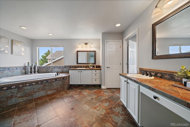 11691 Riverdale Dr, Parker, CO 80138 - full bathroom featuring healthy amount of natural light, two vanities, a garden tub, and recessed lighting