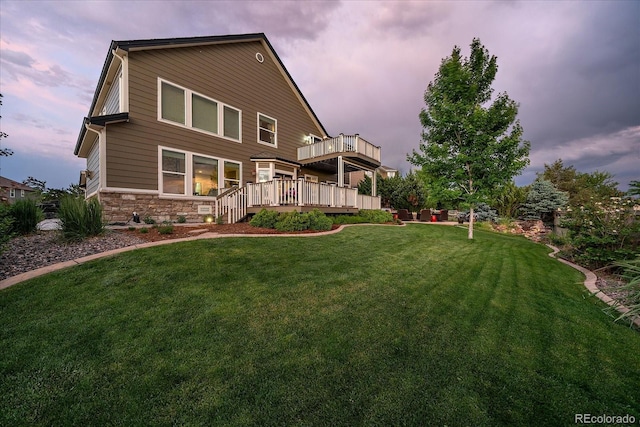 11691 Riverdale Dr, Parker, CO 80138 - back of property at dusk featuring stone siding, a yard, and a deck