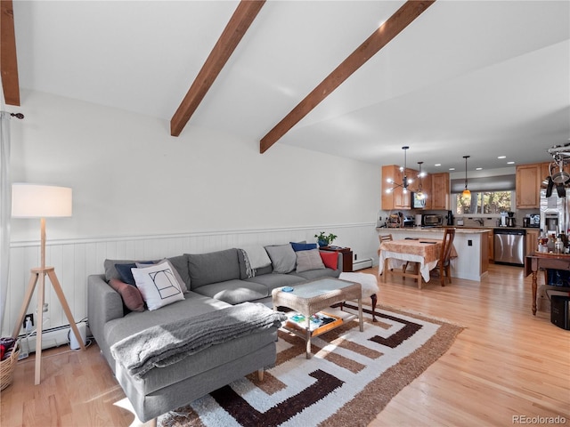 living room with a wainscoted wall, a baseboard radiator, light wood finished floors, and recessed lighting