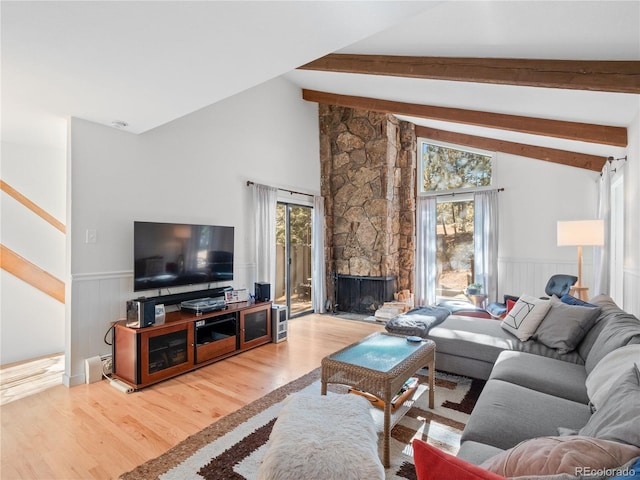 living area featuring a wealth of natural light, wainscoting, vaulted ceiling with beams, and wood finished floors