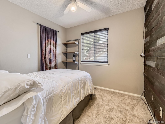 carpeted bedroom with a textured ceiling, baseboards, and ceiling fan