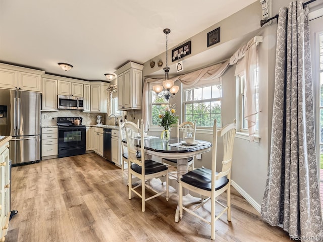 dining space with light wood-style floors, a chandelier, and baseboards
