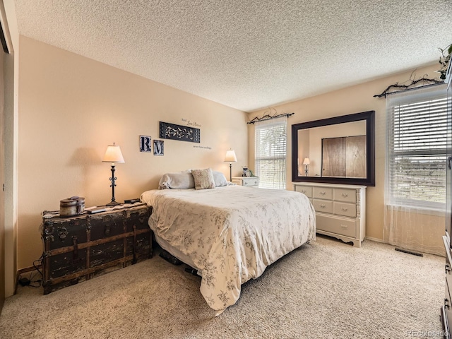 bedroom with light carpet and a textured ceiling