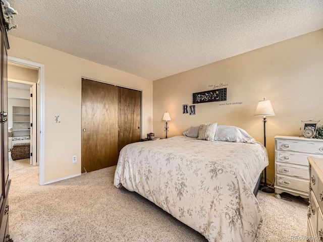 bedroom featuring a closet, a textured ceiling, and light colored carpet