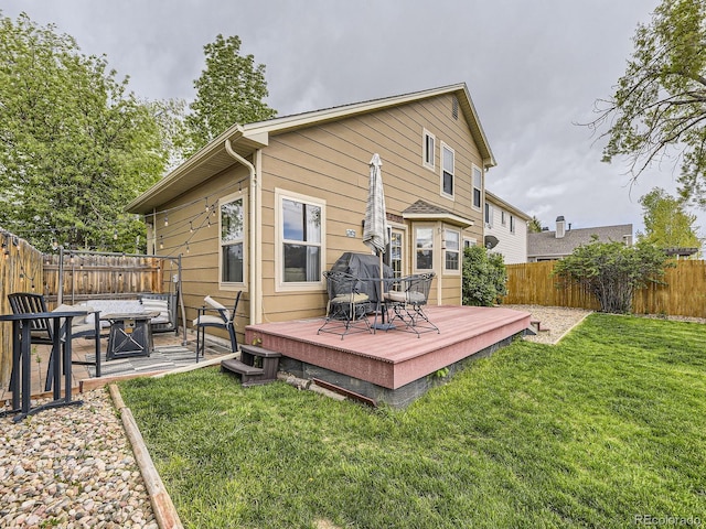 rear view of house with a fire pit and a deck